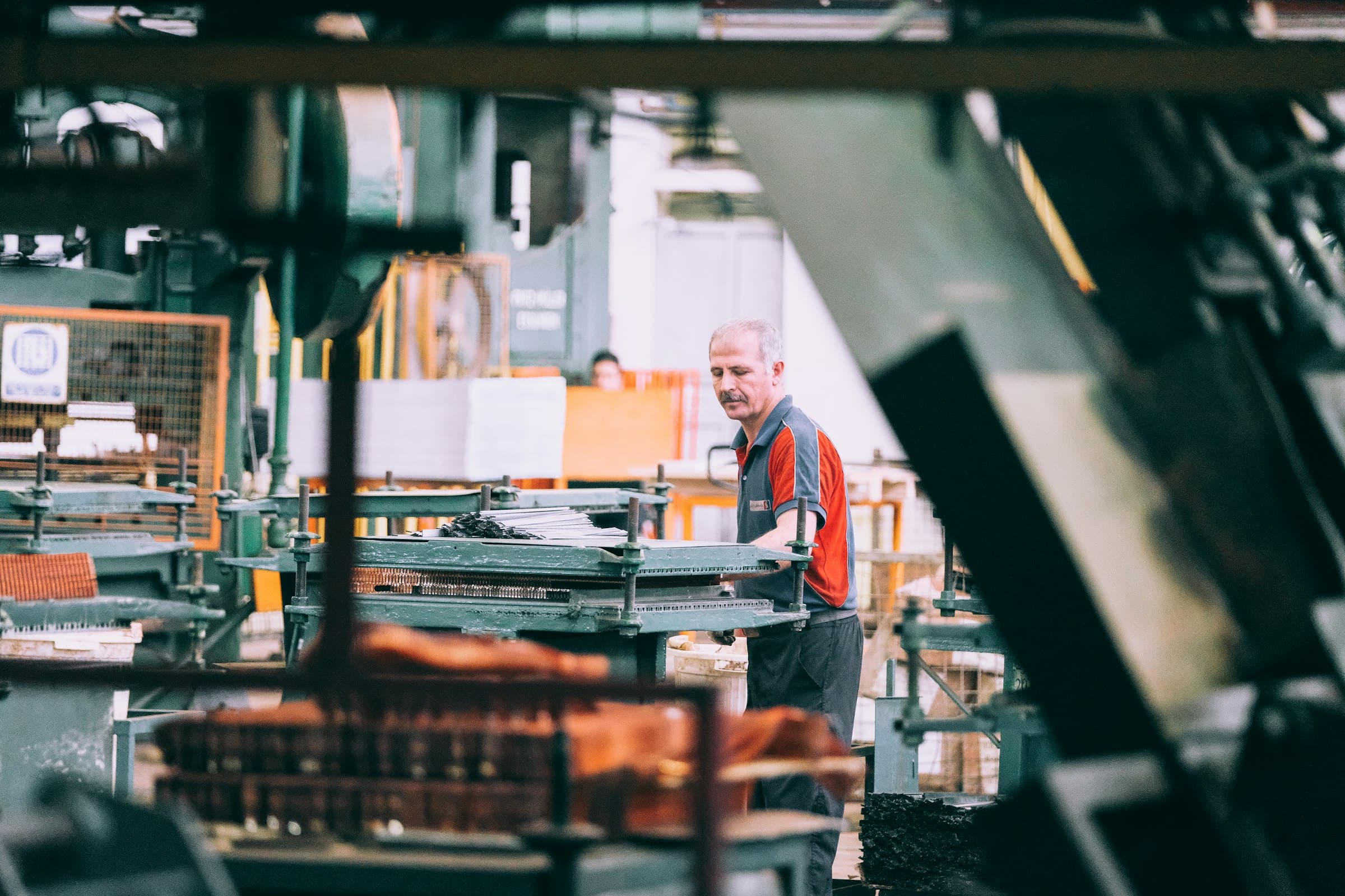 Operatore al lavoro su una macchina in reparto produttivo